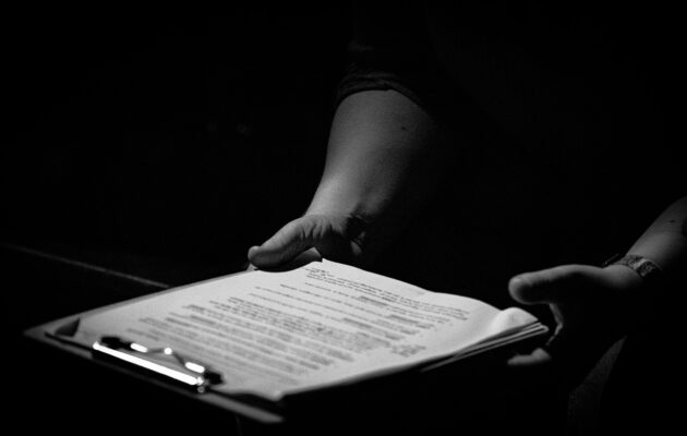 Black and white image of clipboard in a person's hands